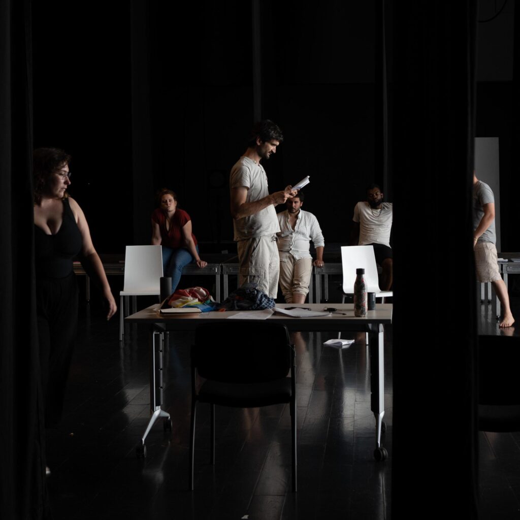 photo d'élèves qui bougent et lisent des textes autour d'une table